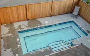 an empty swimming pool with a fence and a chair at Griz Inn by Fernie Central Reservations - Right on The Slopes in Fernie