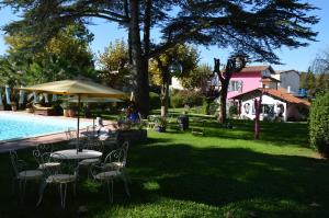 a backyard with a table and chairs and a pool at La Villa Rose in Blaye