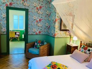 a bedroom with a bed and a chair in it at La Villa Rose in Blaye