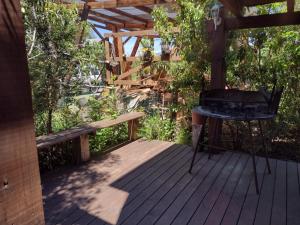 a wooden deck with a grill and a bench at Natures Balcony Reclaimed Wood Cabin with Villarrica Volcano and Majestic Peak Views in Pucón