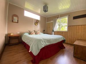a bedroom with a large bed with a window at Natures Balcony Reclaimed Wood Cabin with Villarrica Volcano and Majestic Peak Views in Pucón