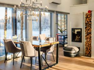 a dining room with a table and chairs and a chandelier at Exclusive Villa Wikkelä Ranua with Sauna & Jacuzzi in Ranua +98 photos