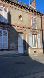 a brick building with a white door on a street at Le Signature Studio in Dreux