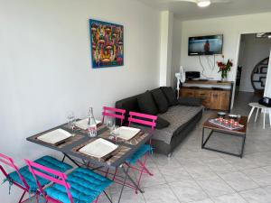 a living room with a table and colorful chairs at Maryvent Apartment in Sainte-Anne