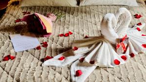 a bed with roses and towels and hearts on it at Pousada & Spa Cantos e Contos in Monte Verde +131 photos