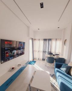 a living room with a blue couch and a tv at Jasmine in Sharm El Sheikh