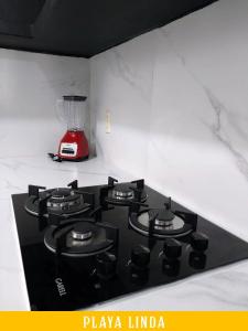 a black stove top with a red blender on a counter at Casa de 4 habitaciones con alberca in Barrio Nuevo