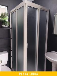 a bathroom with a glass shower with a toilet and a sink at Casa de 4 habitaciones con alberca in Barrio Nuevo +9 photos
