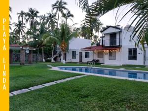 a house with a swimming pool in front of a yard at Casa de 4 habitaciones con alberca in Barrio Nuevo