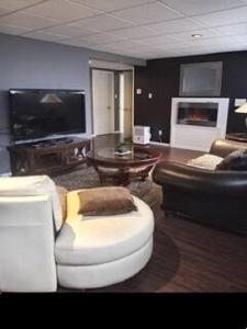 a living room with a couch and a table at Villa le Voyageur in Sherbrooke
