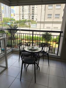 a table and chairs in a room with a balcony at Studio Flat - Guarulhos -Airport Aeroporto - Bosque Maia - Cidade Maia in Guarulhos