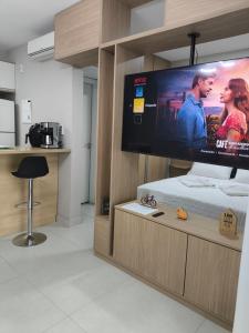 a room with a large flat screen tv on a bed at Studio Flat - Guarulhos -Airport Aeroporto - Bosque Maia - Cidade Maia in Guarulhos