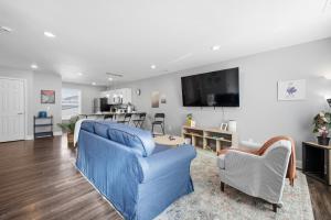 a living room with a blue couch and a tv at Sun Valley Loft, Close to Mosaic! in Saint Joseph