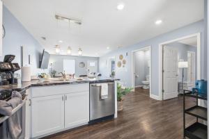 a kitchen with white cabinets and a sink at Sun Valley Loft, Close to Mosaic! in Saint Joseph