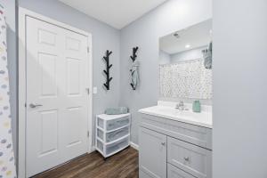 a white bathroom with a sink and a mirror at Sun Valley Loft, Close to Mosaic! in Saint Joseph +19 photos