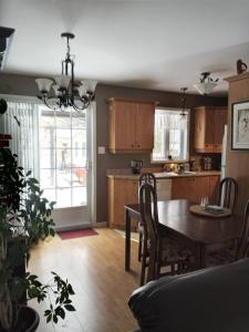 a kitchen with a table and a dining room at Villa le Voyageur in Sherbrooke