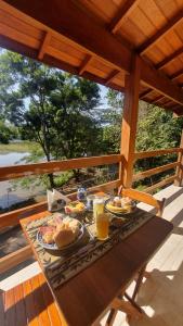 a table with food and drinks on a porch at Pousada Mirante Do Lago in Lindóia
