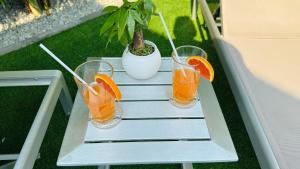 three glasses of orange juice and a potted plant at Lagoon Poolvillas Pattaya in Ban Huai Yai