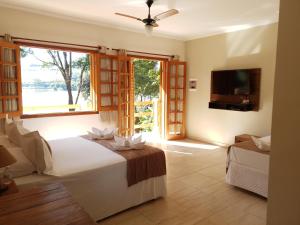 a bedroom with a bed and a tv and a window at Pousada Mirante Do Lago in Lindóia +64 photos