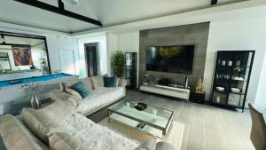a living room with a couch and a tv at Lagoon Poolvillas Pattaya in Ban Huai Yai