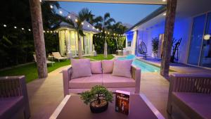 a living room with a couch on a patio at Lagoon Poolvillas Pattaya in Ban Huai Yai