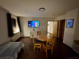 a room with a table and a bed and a television at Ferien- und Monteurwohnung in Borna Nr 5 in Borna