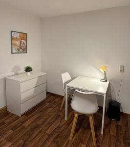 a white desk with two chairs and a dresser in a room at Ferien- und Monteurwohnung in Borna Nr 5 in Borna +4 photos