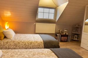 a bedroom with two beds and a window at Le Monciat in Lessines