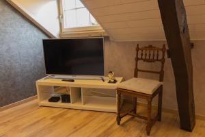a living room with a tv and a chair at Le Monciat in Lessines