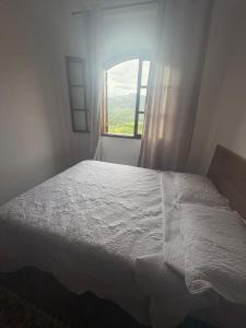 a bedroom with a white bed and a window at Maxi conforto e vista para o Itacolomi in Ouro Preto +86 photos