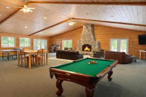 a pool table in a room with a fireplace at River Road Lodge by NW Comfy Cabins in Leavenworth