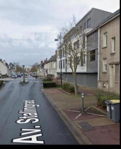 an empty street with buildings and a street sign on the road at Le precieux de la Gare in Saint-Pierre-des-Corps