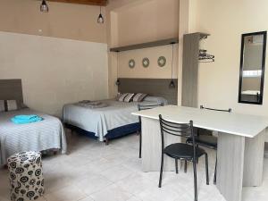 a room with two beds and a table and chairs at Venezia-Monoambiente in Villa Mercedes