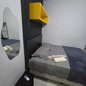a bedroom with a bed and a yellow mirror at Ap Lagoa da Prata com Ar condicionado in Lagoa da Prata