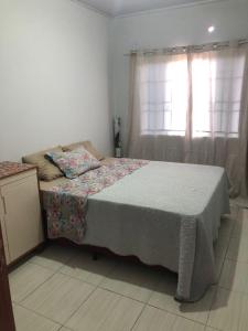 a bedroom with a bed and a window with curtains at Casa para diarias e empresas in Cianorte
