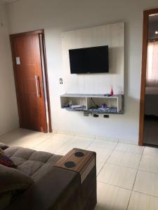 a living room with a couch and a television on a wall at Casa para diarias e empresas in Cianorte +3 photos