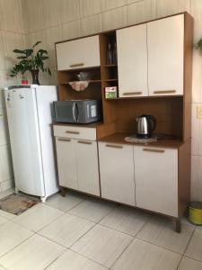 a kitchen with a refrigerator and a microwave at Casa para diarias e empresas in Cianorte