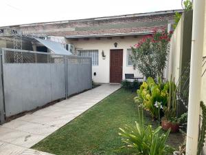 a white house with a fence and a yard at Venezia-Monoambiente in Villa Mercedes
