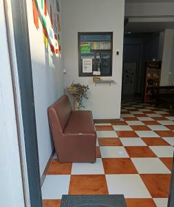 a chair in a hallway with a checkered floor at เส้นดี โฮสเทล Sendee Hostel in Phitsanulok