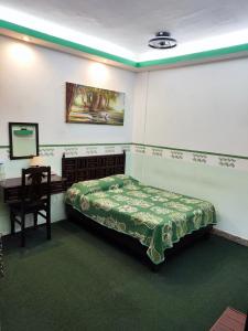 a bedroom with a bed and a desk and a table at Hotel Mesón del Rey in Oaxaca City