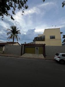 a house with a palm tree in front of a building at Pousada Gaivota in Trindade +8 photos