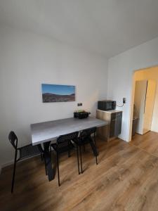 a table in a room with chairs and a kitchen at 3-Zimmer Wohnung - 3 OG in Duisburg