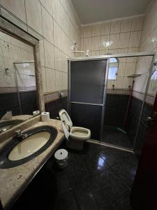 a bathroom with a toilet and a sink and a shower at Pousada Gaivota in Trindade