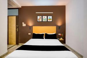 a bedroom with a large white bed with black pillows at Hotel O KL khari Near Ashram Mein Metro in New Delhi