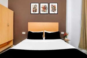 a bedroom with a large bed with four pictures on the wall at Hotel O KL khari Near Ashram Mein Metro in New Delhi