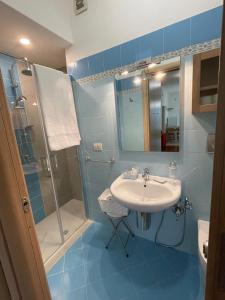 a blue bathroom with a sink and a shower at Suite Isernia Centro in Isernia