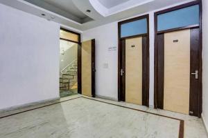 an empty room with doors and windows at Hotel O KL khari Near Ashram Mein Metro in New Delhi +5 photos