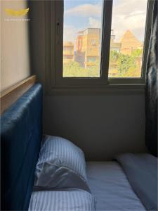 a bed in a room with a window at Zak Pyramids Inn in Cairo