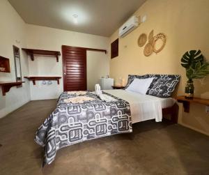 a bedroom with a bed with a black and white comforter at Pousada Areias de Flecheiras in Flecheiras +92 photos