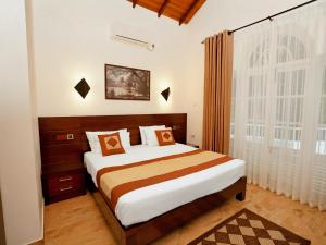a bedroom with a bed and a large window at Samindra Villa in Kandy